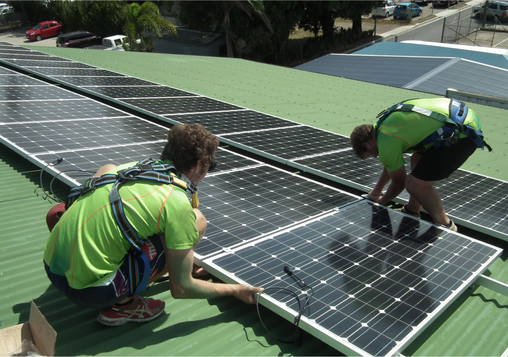 Installers working on solar panels on green roof