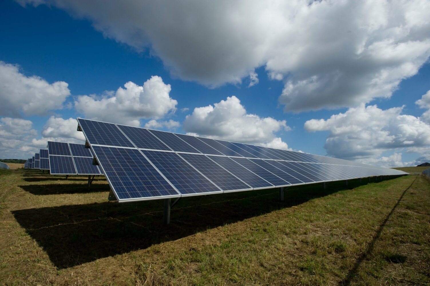 Solar panels on a field on a bright cloudy day