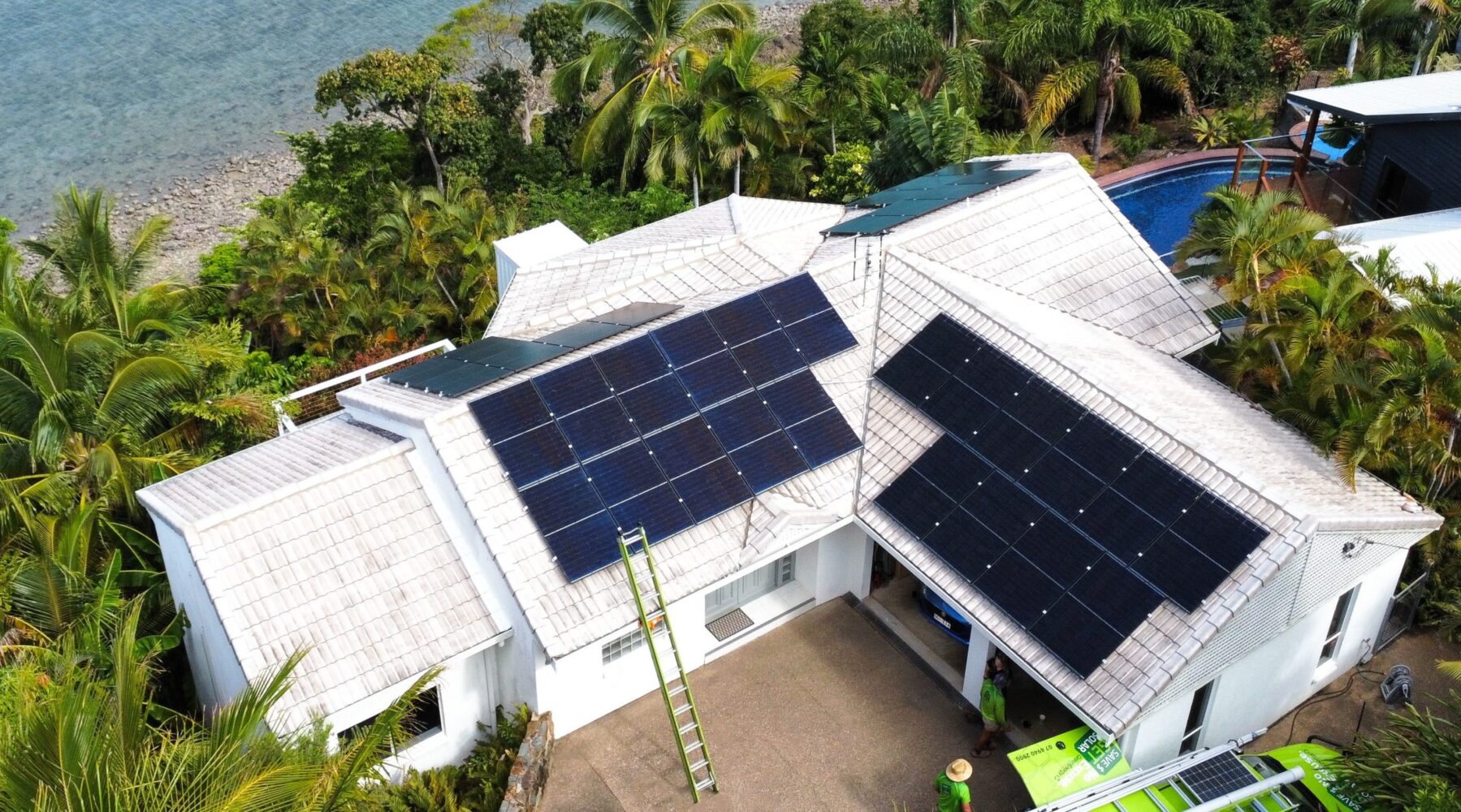 Solar panels on roof of house next to a lake