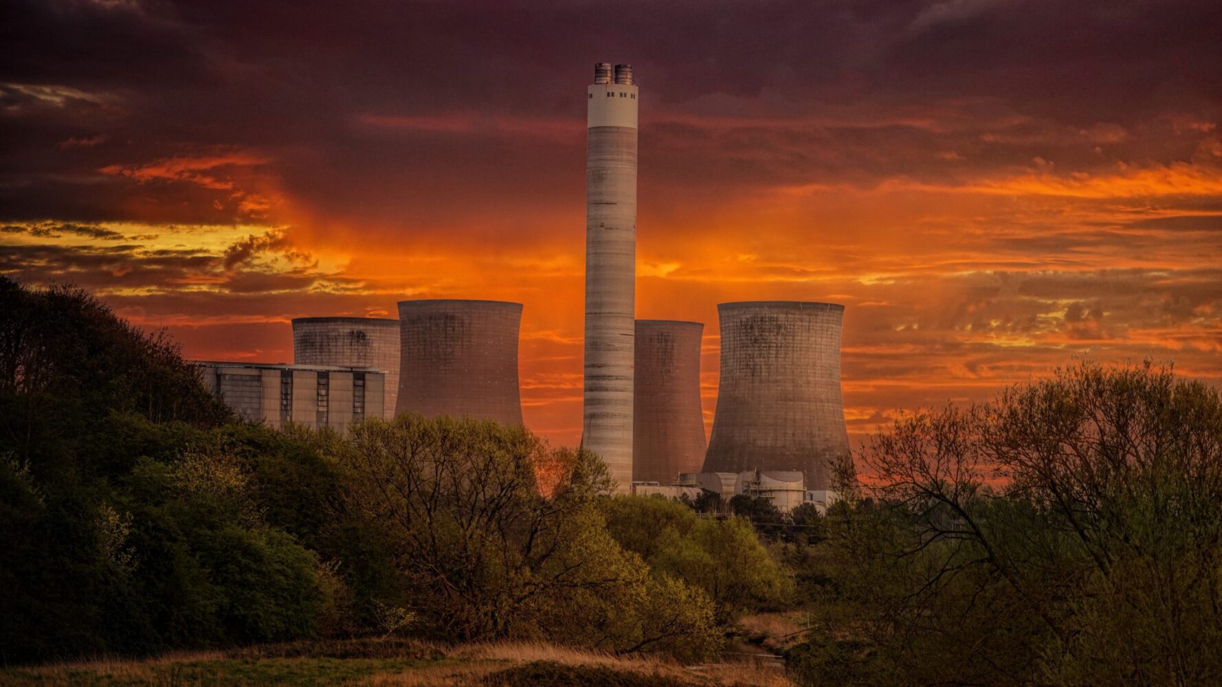 White nuclear plant silo under orange sky at sunset