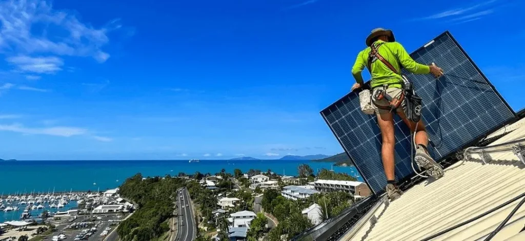 Residential Solar Solutions – Installer securing a solar panel on a sloped roof in the Whitsundays, promoting renewable energy. Case Studies for solar energy.