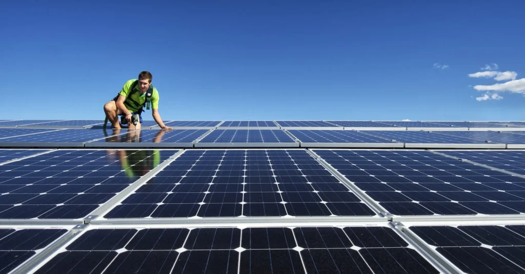 Solar installer on the roof mounting solar panels for renewable energy installation. Solar power townsville